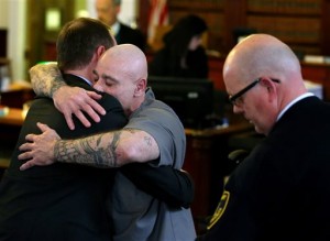George Perrot, center, gets a hug from his attorney Nicholas Perros after a trial judge ordered him to be released yesterday on his own recognizance after his bail hearing inside the Bristol County Superior Court in New Bedford. (Jonathan Wiggs/The Boston Globe via AP)