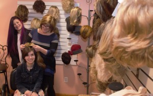 Balance Cancer and Wellness Salon and Boutique owner Susan Manolakis is assisted by Flo Castonguay as they fit a client for a wig. (Photo by Lynn Bosher)