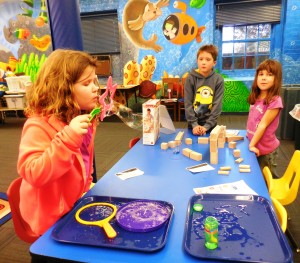 Jordan blows bubbles from the new gravity STEM kit at the Athenaeum while Noah and Gianna look on.