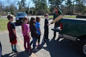 Students line up to help unload the materials that David Dion brought to make the raised garden beds.