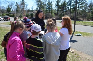 Claire Adams hands out materials to students before construction of the raised garden beds begins.