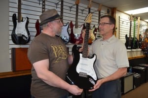Doug Cotton, owner of Whip City Music, donates a Palmer PE-Core electric guitar for this Saturday's first Articulture WESTFIELD celebration. Bill Westerlind from Articulture WESTFIELD accepts the guitar from Cotton.