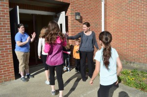 Colleen Brenzel and Melanie McNamara high five kids as they return from their run as part of the BOKS program at the Highland Elementary School.
