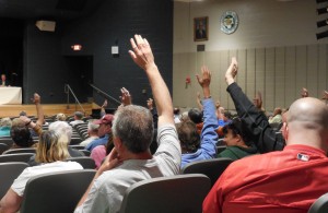 Hands were raised for a vote count for the name change, which succeeded 74 to 56. (Photo by Amy Porter)