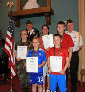 American Post 124 awarded its first American Legion School Medals to four Saint Mary’s Parish Students during the Saint Mary’s Parish School Memorial Day Assembly.  Receiving medals were 8th graders: Aynsley Davidson and Jack Watson who will be going to the High School in September and 5th graders: Amelia Willenborg and Everett Stec who will be going to Middle School in September. Pictured left to right:  Aynsley Davidson (8th Grade), Gene Theroux, Past Commander, Amelia Willenborg (5th Grade), Lynn Collins - Principal Saint Mary's Parish School, Everett Stec (5th Grade), Jack Watson (8th Grade) & George Fahey, Past Commander. (Photo by Don Wielgus)