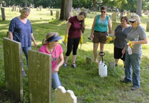 Cindy Gaylord, kneeling, discussing headstone cleaning procedures at the Old Burying Ground.
