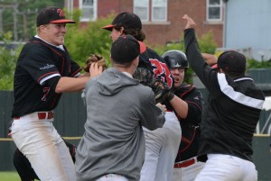 Westfield senior Sean Murphy, left, and several other teammates mob pitcher Ryan Towle near the pitcher’s mount after the Bombers eliminated the Taconic Braves in Wednesday’s tournament semifinal. (Photo by Chris Putz)