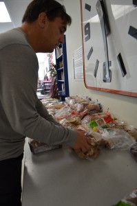 Volunteer Jeff Castonguay organizes the bread table at the Westfield Food Pantry on Friday morning.