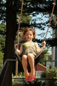 Willow, age  6, is having fun on the swings during this week's Westfield Park & Rec Adventure Zone. (Photo by Kellie Adam)