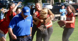 Longtime West Springfield head softball coach Deke Pillsbury, left, walks off the field as players for Westfield begin to celebrate a thrilling 1-0 postseason victory Thursday at Mitteneague Park Field. (Photo by Chris Putz)