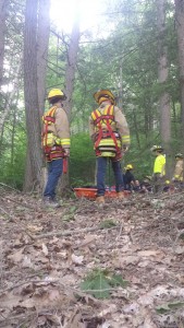 Firefighters Dave Matsuk and Aaron Bannish stand harnessed to Stokes basket.
