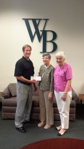 Jim Hagan, left, presents a check to Sisters Maxyne Schneider and Betsy Sullivan.