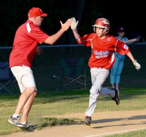 Westfield National’s Jared Noel, right, high fives his coach after rounding home plate during a home run trot in the fourth inning Wednesday night at Amherst. (Photo by Chris Putz)