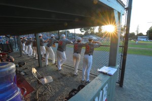 Tri Valley (California) players look out from their dugout as the sun peaks in during the Babe Ruth Baseball 14-Year-Old World Series championship game at Bullens Field. The sun set, both literally and figuratively, on the tournament on its final day. (Photo by Marc St. Onge)