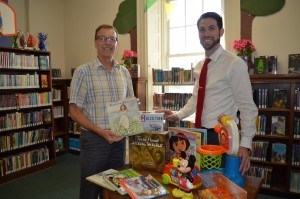 Bill Westerlind, president of the Friends of the Westfield Athenaeum, and Daniel Paquette, Athenaeum director, encourage donations of toys and books for a November fundraiser.