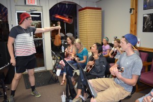 Kyle Bessette reviews chords with the new members of the Whip City Ukesters.