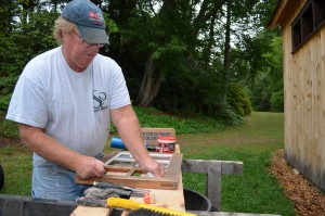 Jack King, a seasonal carpenter at Stanley Park, re-glazes the windows of the Carriage House.