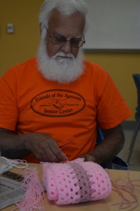Edward Ekmalian puts the finishing touches on a pink scarf Wednesday morning at the Westfield Senior Center that will be donated to the Rays of Hope Run and Walk for breast cancer survivors.