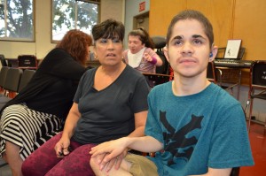 Michael Sousa listens to musical instructions as communications specialist Marietta Pami offers support.