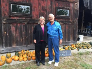 Co-owner of Yellow Stonehouse Farm, Connie Adams, and member Joe Croteau, pose for a picture with the pumpkins in the background. (Photo by Greg Fitzpatrick)