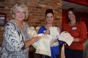 Joanne Krause, Valli Jo Flynn, and Evelyn Turcotte show dresses, blankets, and premie pouches that will be created through the Angel Babies Project.