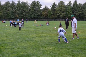 Westfield Parks and Recreation Department coach Jeff Sarat watches as Joshua Escarpita, 5, practices kicking the soccer ball prior to a Pee Wee soccer game.