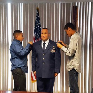 Ramon Diaz, Jr.' sons Jake, 12 (left) and Nicholas, 14, put the new rank of silver oak leaf clusters on the Lieutenant Colonel during his promotion ceremony on Sunday. (Submitted photo)