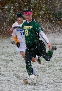 St. Mary’s Padraig Smith (8) steps into a kick as a Pathfinder defender shadows the play. (Photo by Chris Putz)