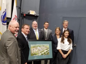 (l-r) Westfield Mayor Sullivan, Nabil Hannoush, State Sen. Humason, State Rep. Velis, Julie Hannoush, Monica Hannoush and Gov. Baker encircle an artist rendering of the proposed plaza at 99 Springfield Rd (WNG file photo)