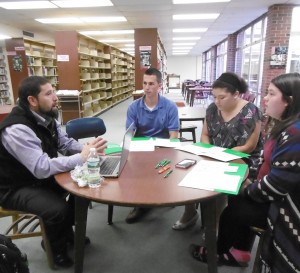 Harold Santiago of HCC admissions talks with Jake Viamari, Sam Rosario and Lauren Hawley. (Photo by Amy Porter)