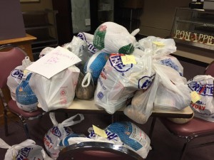 Food piled on a desk at the food drive Monday. (Photo credit: Greg Fitzpatrick)