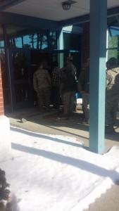 Members of the 104th Air National Guard line up out of the door of the dining hall to get their Carando holiday meal