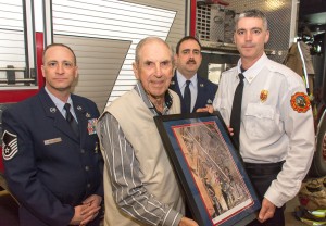 Retired Lt. Col. Edwin M. Renkowicz presents the numbered print of painting to Dep. Chief Andrew Hart, as ANG members John Mitchell and Larry Buell observe