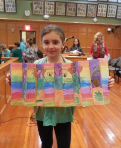 Grace Trempe, a fourth grader at Paper Mill Elementary, shows her artwork along with her classmates to the School Committee at the start of the meeting on Monday. (Photo by Amy Porter)