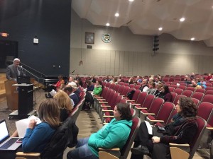 The school committee is seen sitting in the front row for the final study presentation, with people in the community in the background. (Photo by Greg Fitzpatrick)