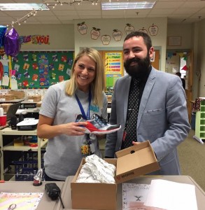 Third grade teacher Katherine Bitzas holds the Reebok shoes while Principal Sal Frieri holds the box open. (Photo by Greg Fitzpatrick)