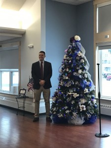 State Representative John Velis (D-Westfield) stands next to a Christmas tree decorated in honor of the Westfield Police Department that is located at the Senior Center.