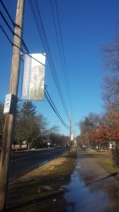The banners in question from Westfield State University, with one in the forefront and another in the background of the photo, both hanging from telephone poles. 