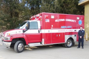 EMT Jake Sanborn stands with the ambulance the Hilltown Community Ambulance Association recently bought via the Northampton Fire Department for $17,500. (Photo by Amy Porter)