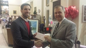 Dan Paquette, left, receiving a donation from Dan Allie, right 