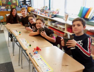 Westfield State student teacher Courtney Connors and second graders in Phil Lewis class show off newly planted flower pots. (Photo by Amy Porter)