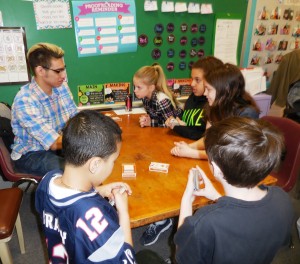 Information Tech senior senior Marc Cintron explains algorithms through card games with Southampton Road fourth graders. (Photo b y Amy Porter)