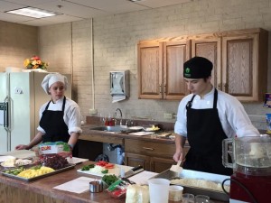 Westfield Technical Academy culinary students Ryen Velozo and Yoeliany Lebron prepare the pizzas they are making for the seniors. (Photo by Greg Fitzpatrick)